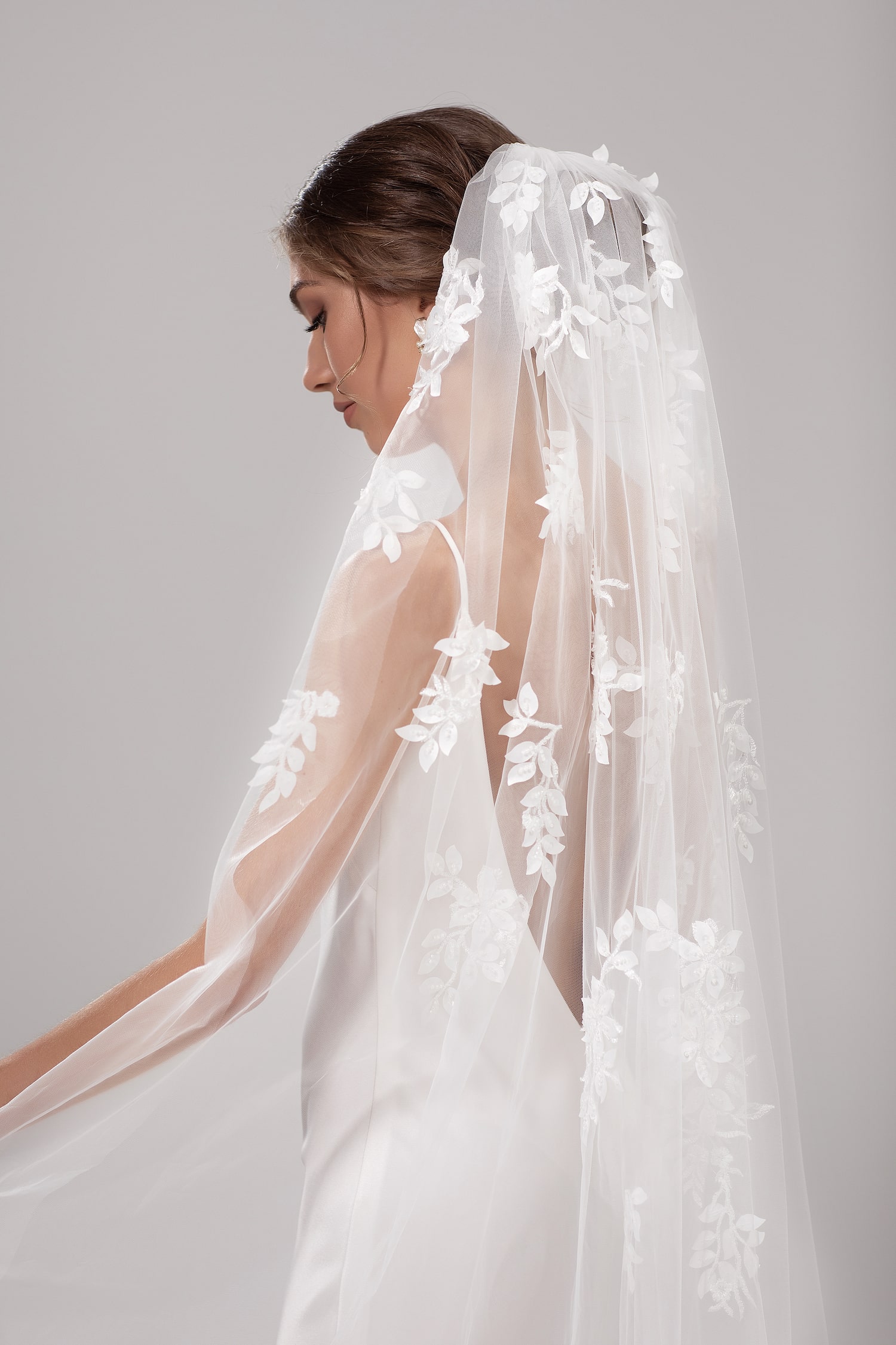 A softly gathered single layer veil with floral 3D lace appliqué trailing from the comb to fingertips.