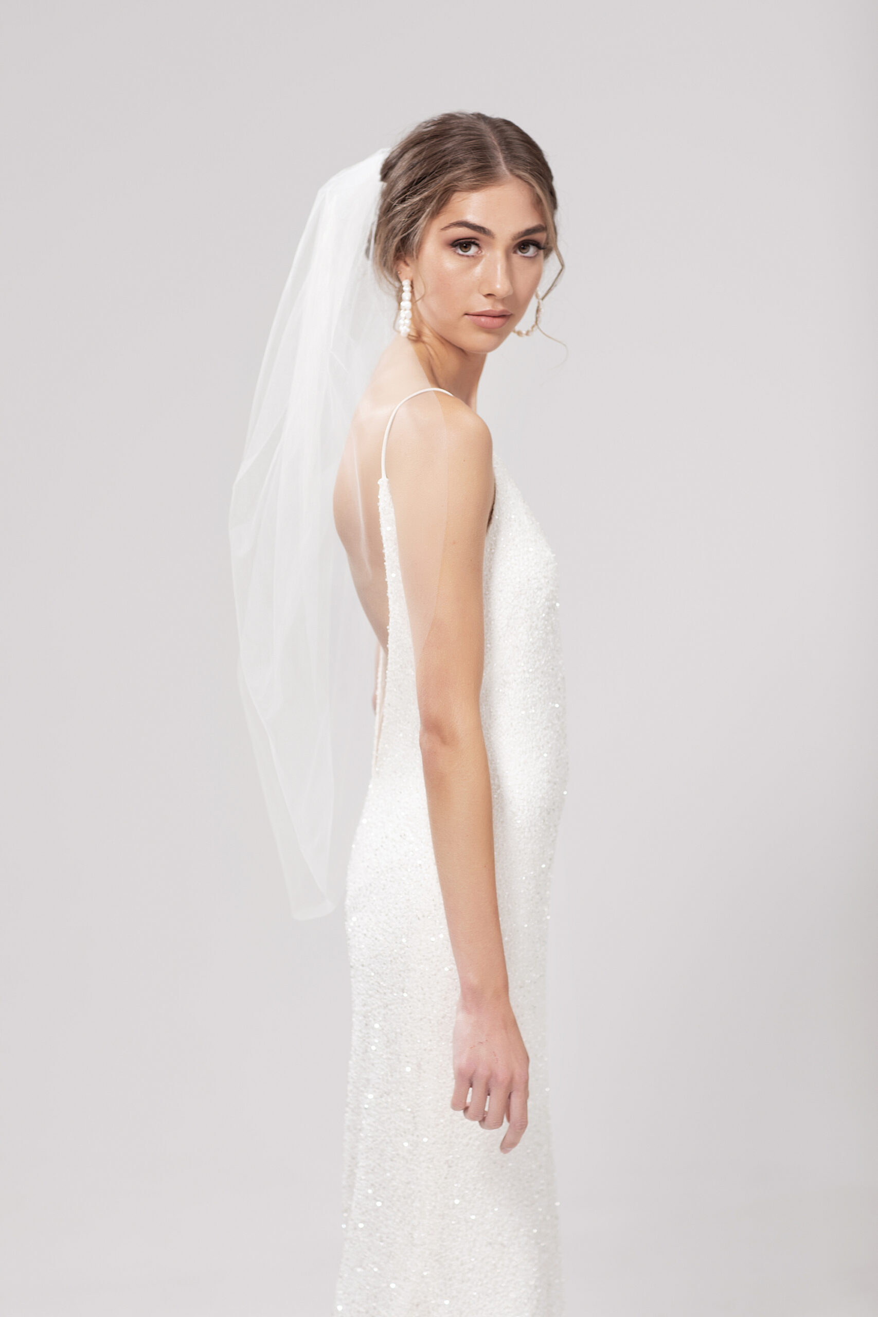 Side view of model wearing Pia, a single layer 95cm tulip style veil.