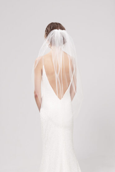 Back view of model wearing Pia, a single layer 95cm tulip style veil gathered on top of a low bun.