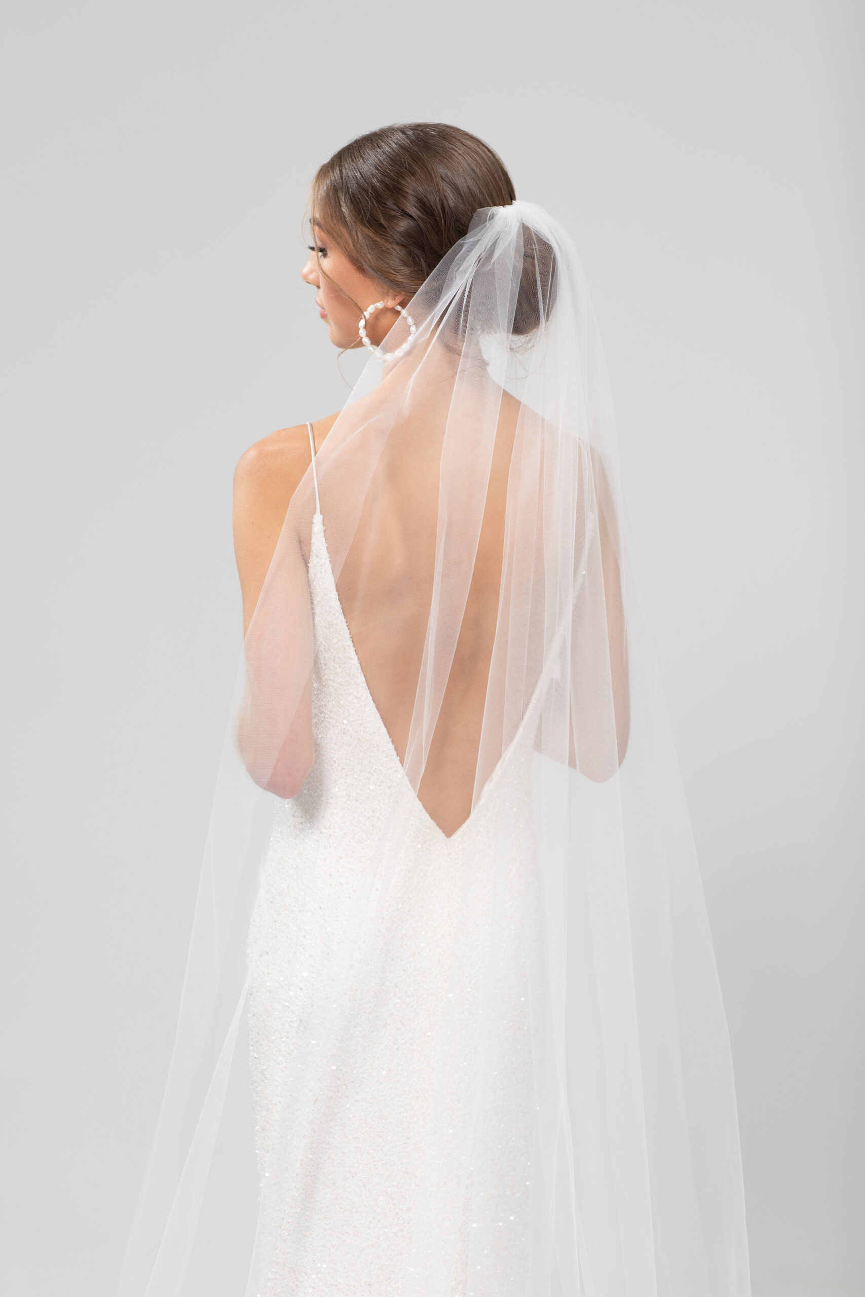 Back view of model wearing rio, a single layer veil 2.2.m veil sitting softly gathered above a low bun.