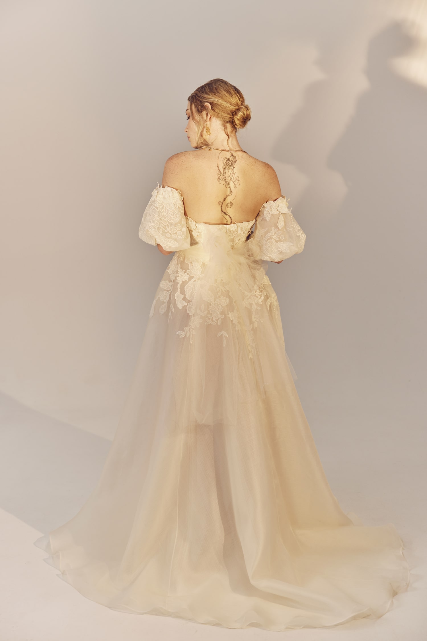 Agnes full length back view - a strapless gown with puff sleeves and embroidered organza motifs