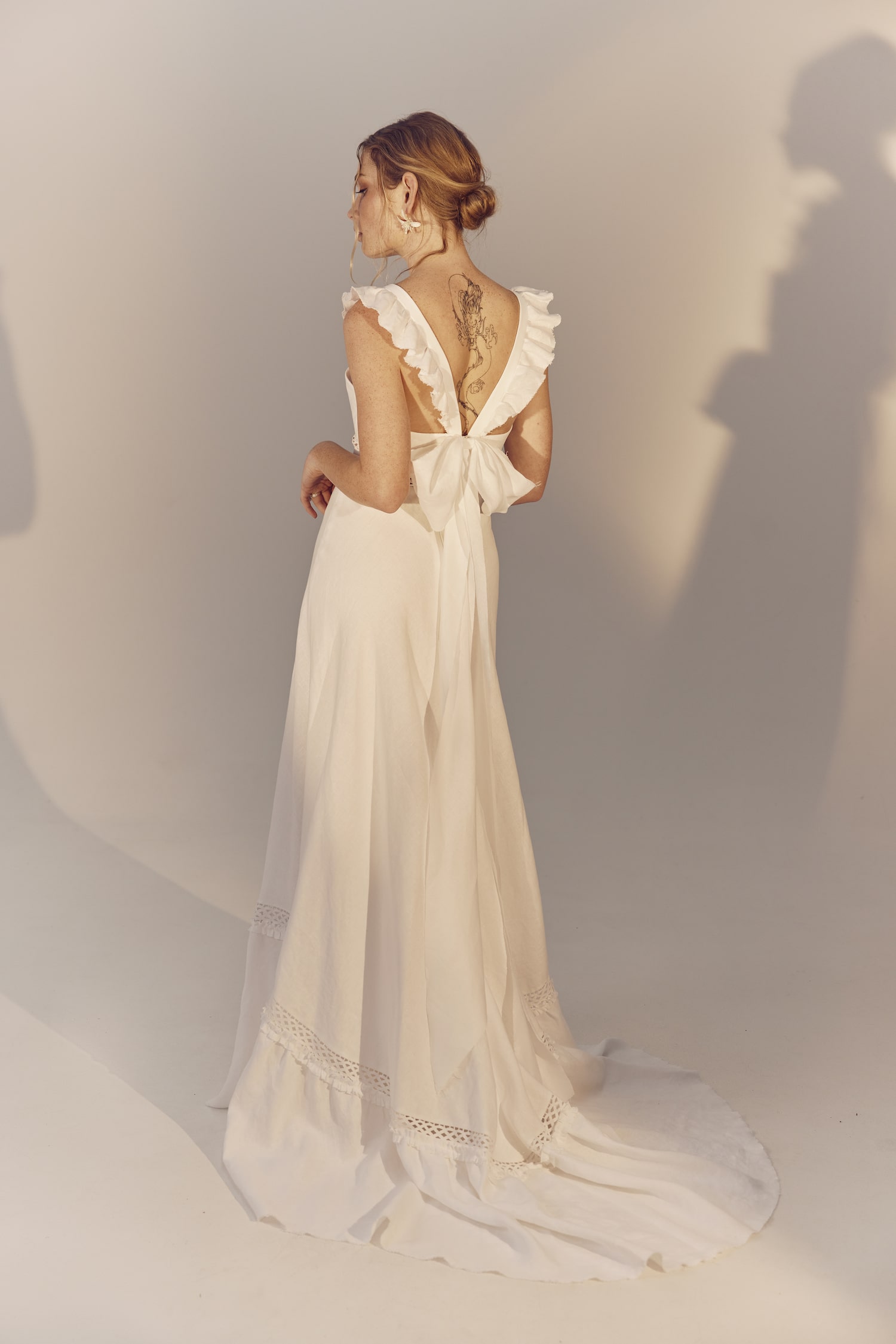 Maggie full length back view - a square neckline white linen gown with frilly cap sleeves
