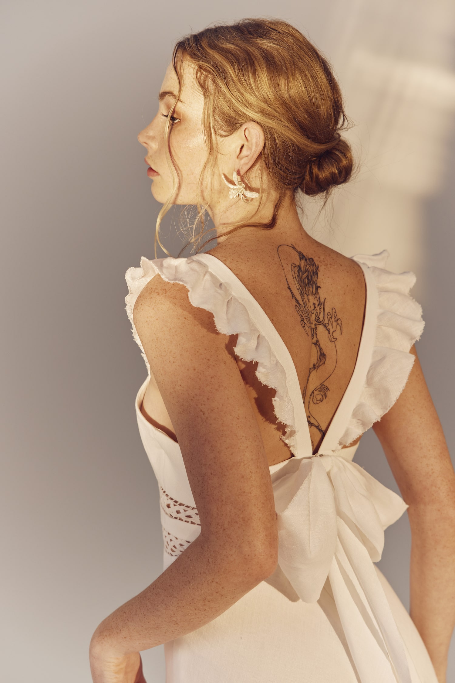 Maggie close up back view - a square neckline white linen gown with frilly cap sleeves
