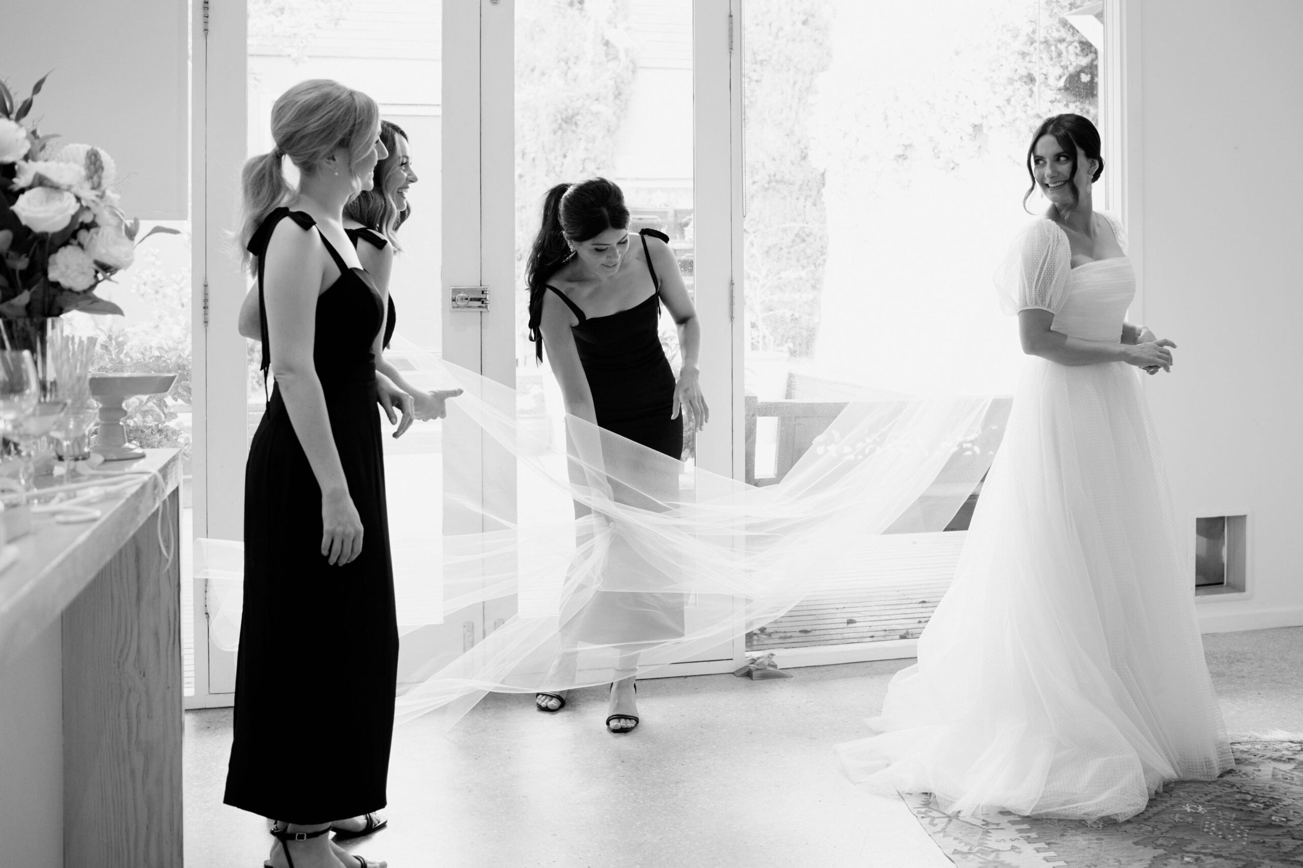 Maddy and bridesmaids getting ready, fluffing out Maddy's veil