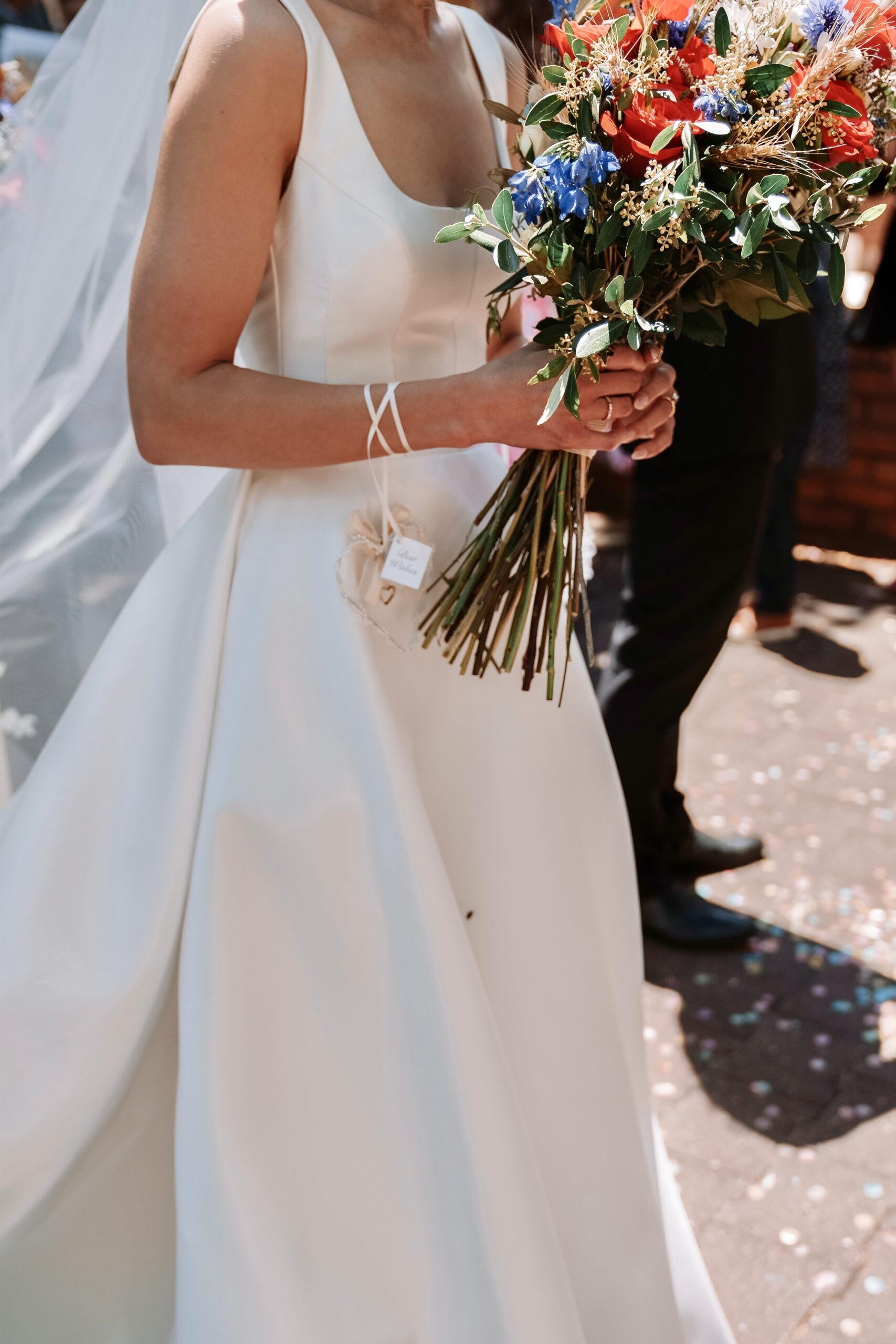 Close up of Maia in her gown holding a colourful bouquet