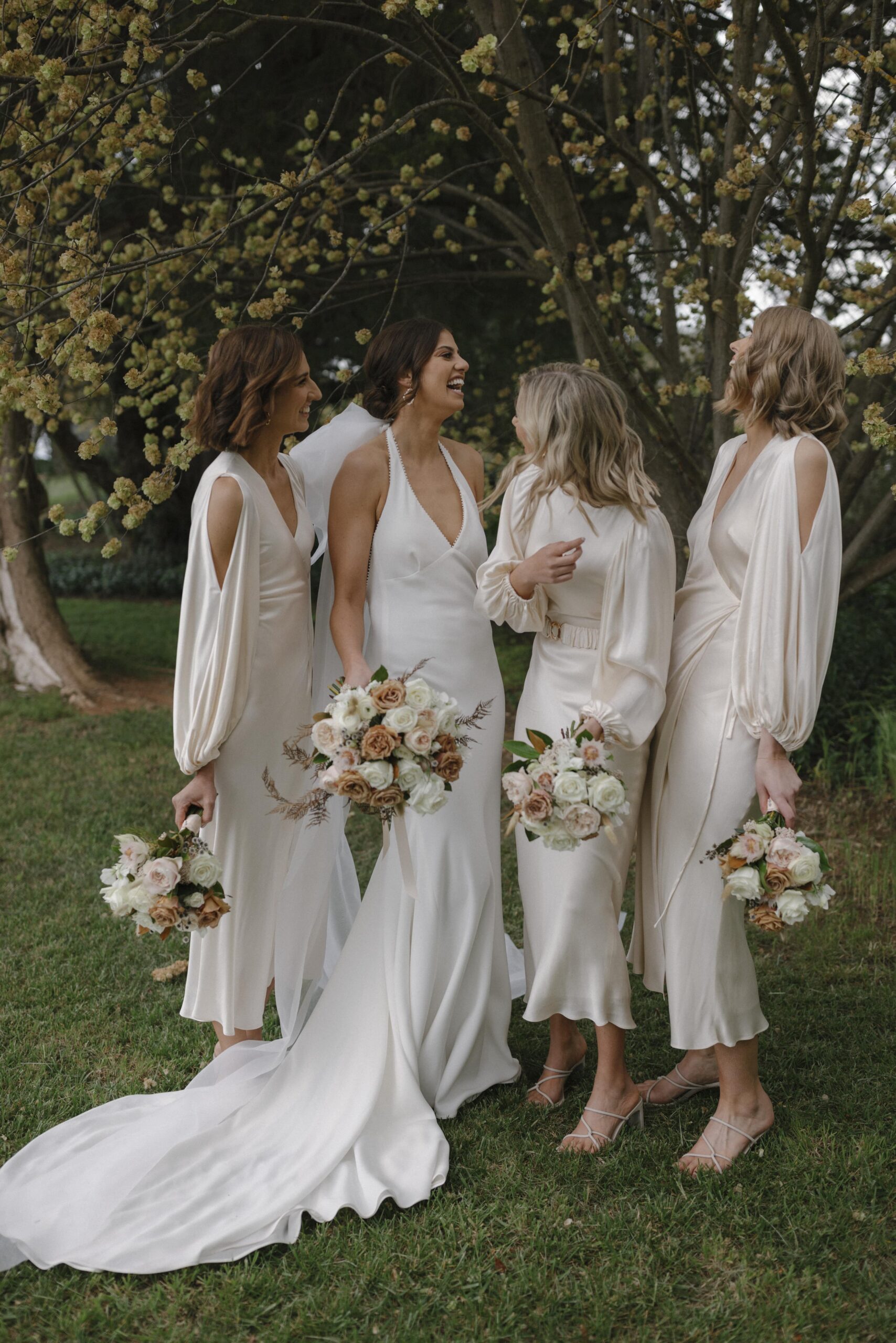 Olivia and bridesmaids holding bouquets caught in a moment of laughter
