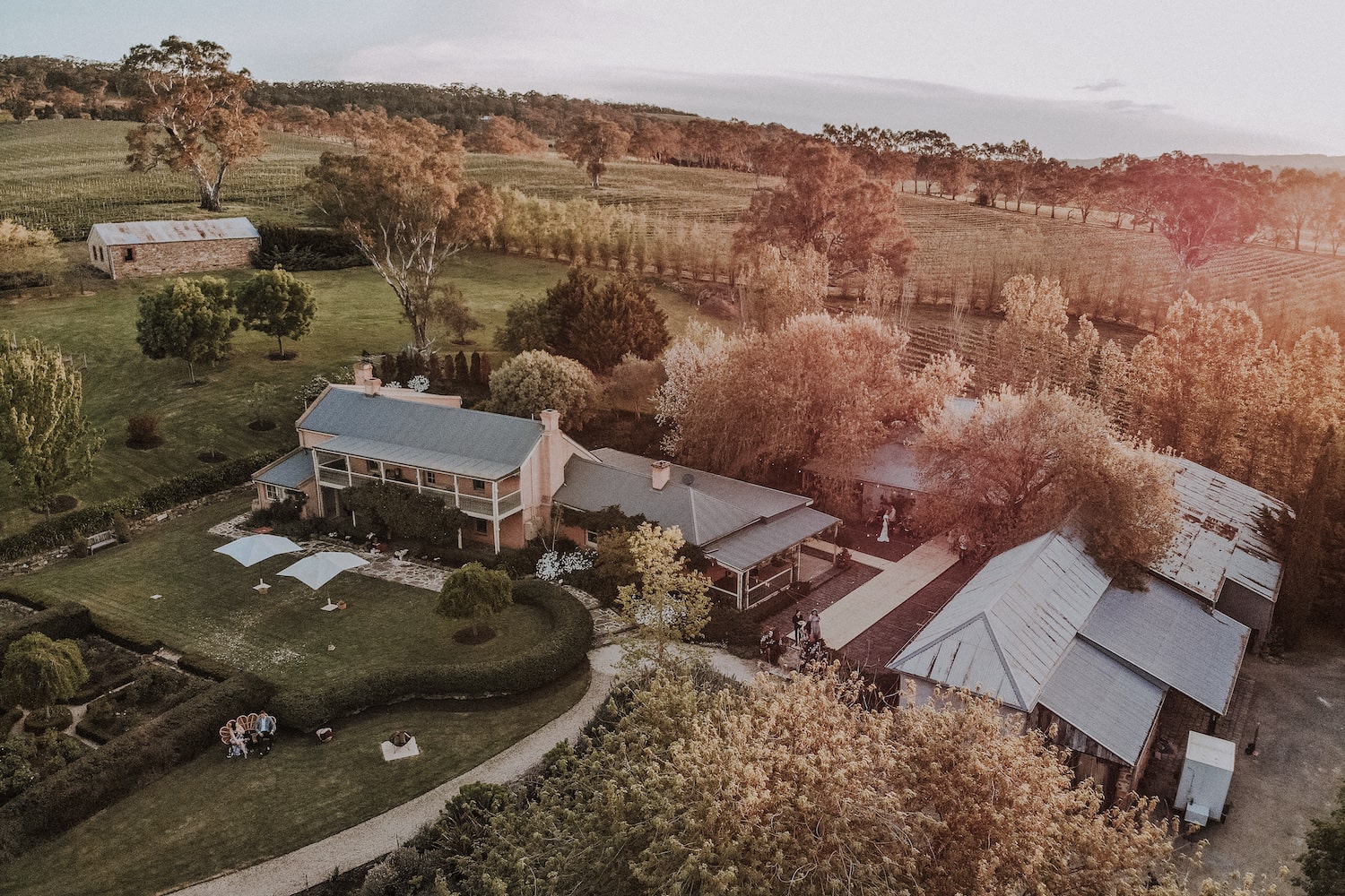 Birds eye view of Adelaide Hills property. Rolling green hills, trees, a large house and barns