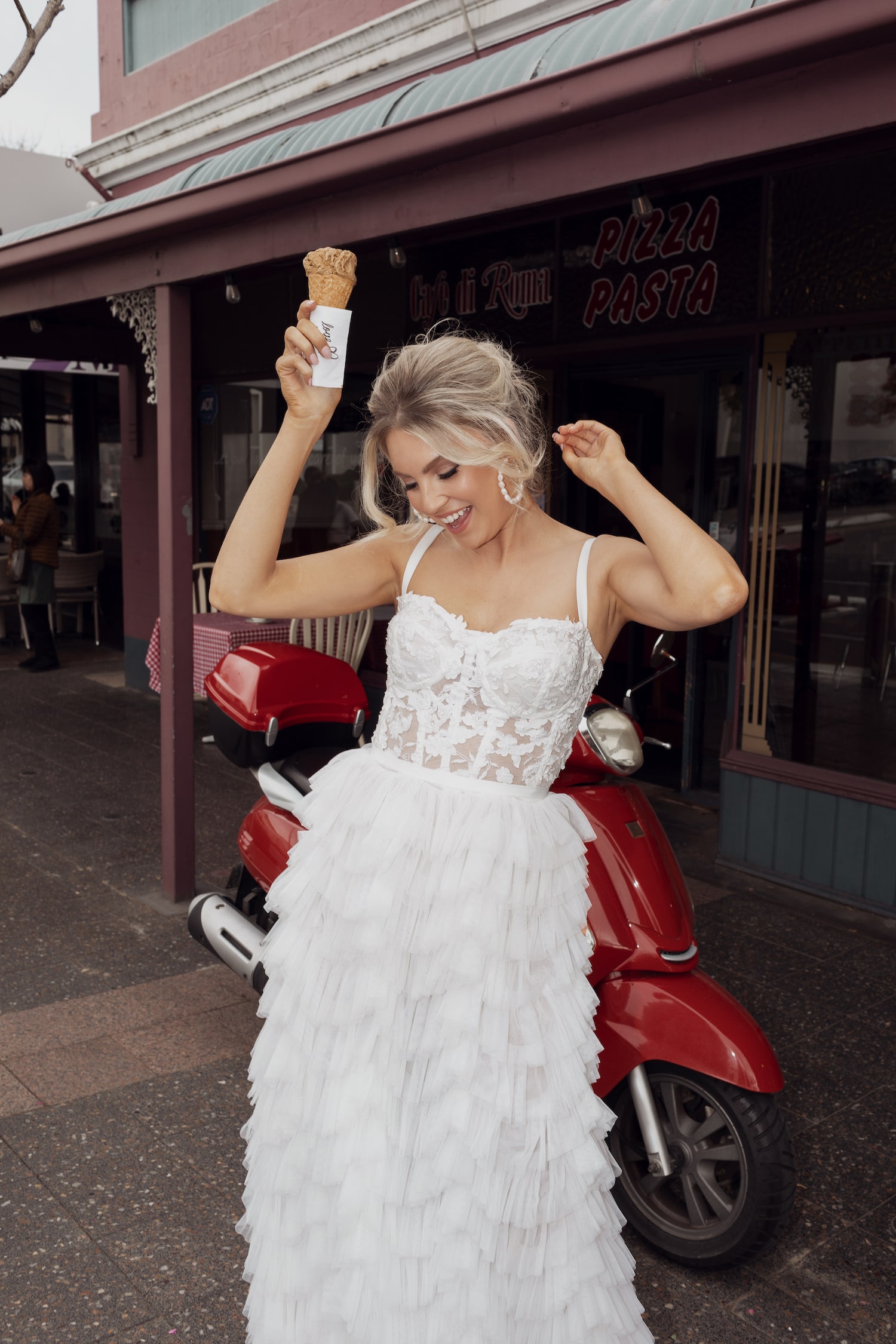Model posing with icecream in front of red scooter wearing the Rikki top and Ricciolina skirt.