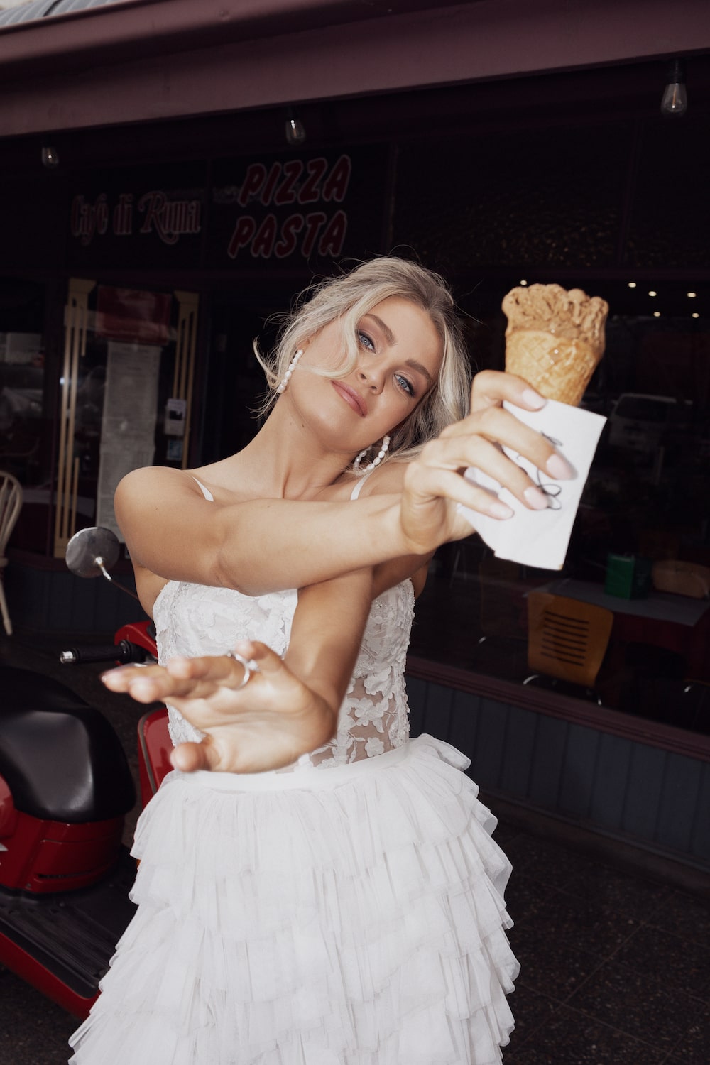 Model posing with icecream in front of red scooter wearing the Rikki top and Ricciolina skirt.