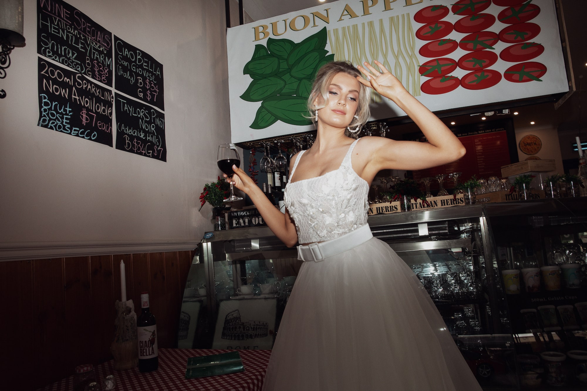 Model posing infront of cake fridge in Italian cafe wearing the Tiziana top and Roma skirt.
