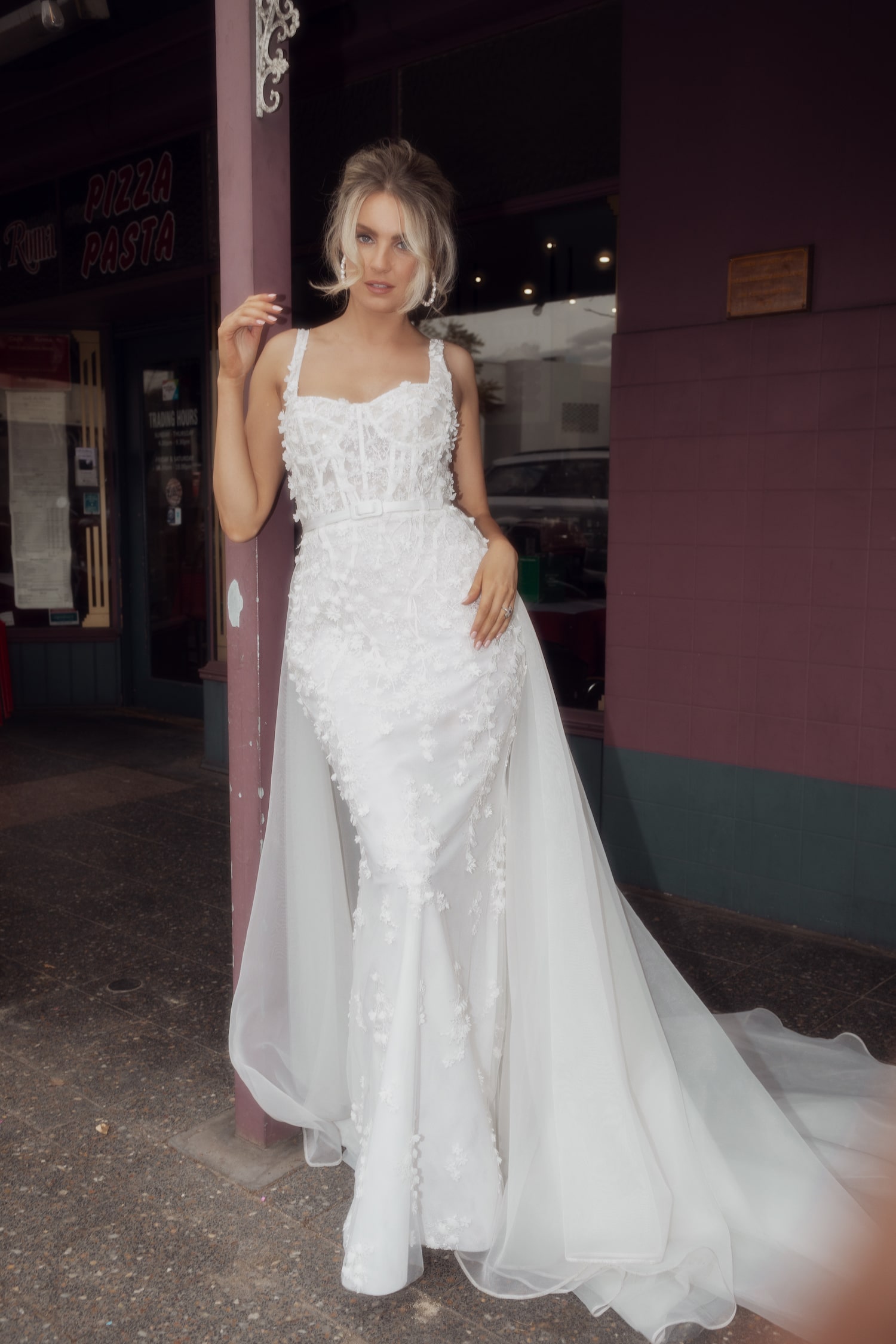 Model posing out the front of Italian cafe wearing the Romantica gown.