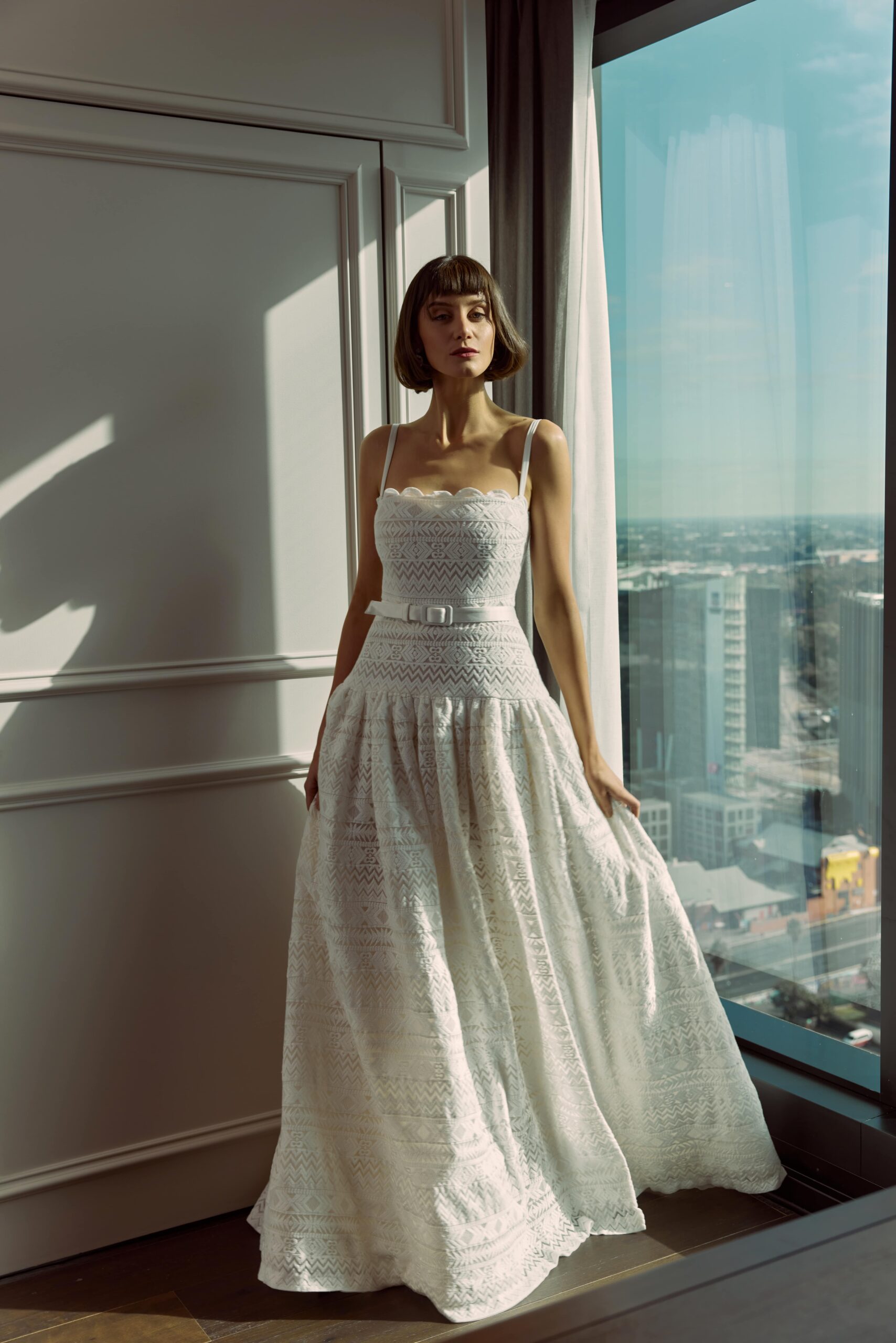 Lucille - An embroidered cotton gown with a drop waist, thin straps, belt and leg split.