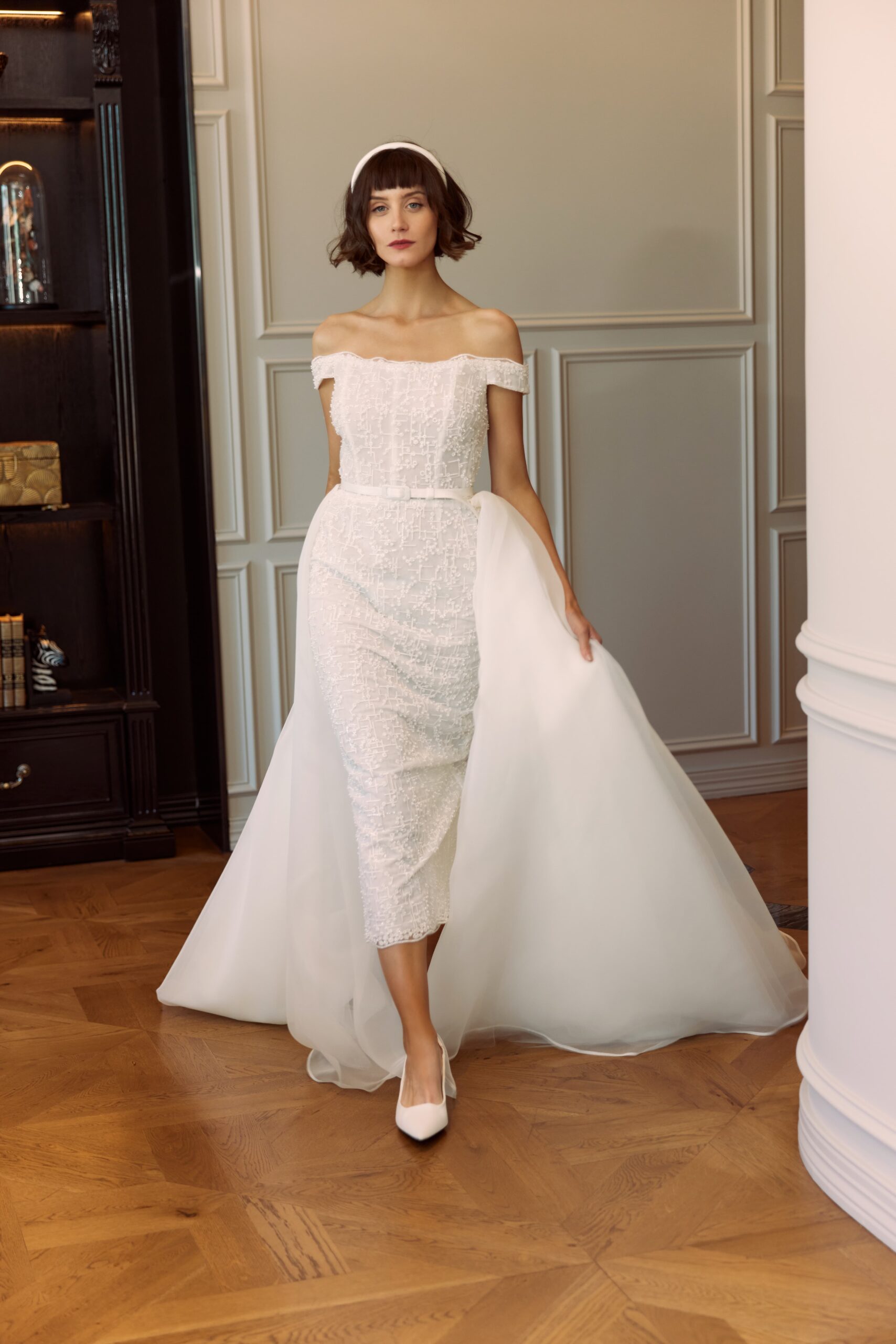 Bijou dress and Mon Cherie train - an off-the-shoulder dress in an embroidered and beaded tulle worn with an organza overskirt. Bijou finishes at the high ankle point.