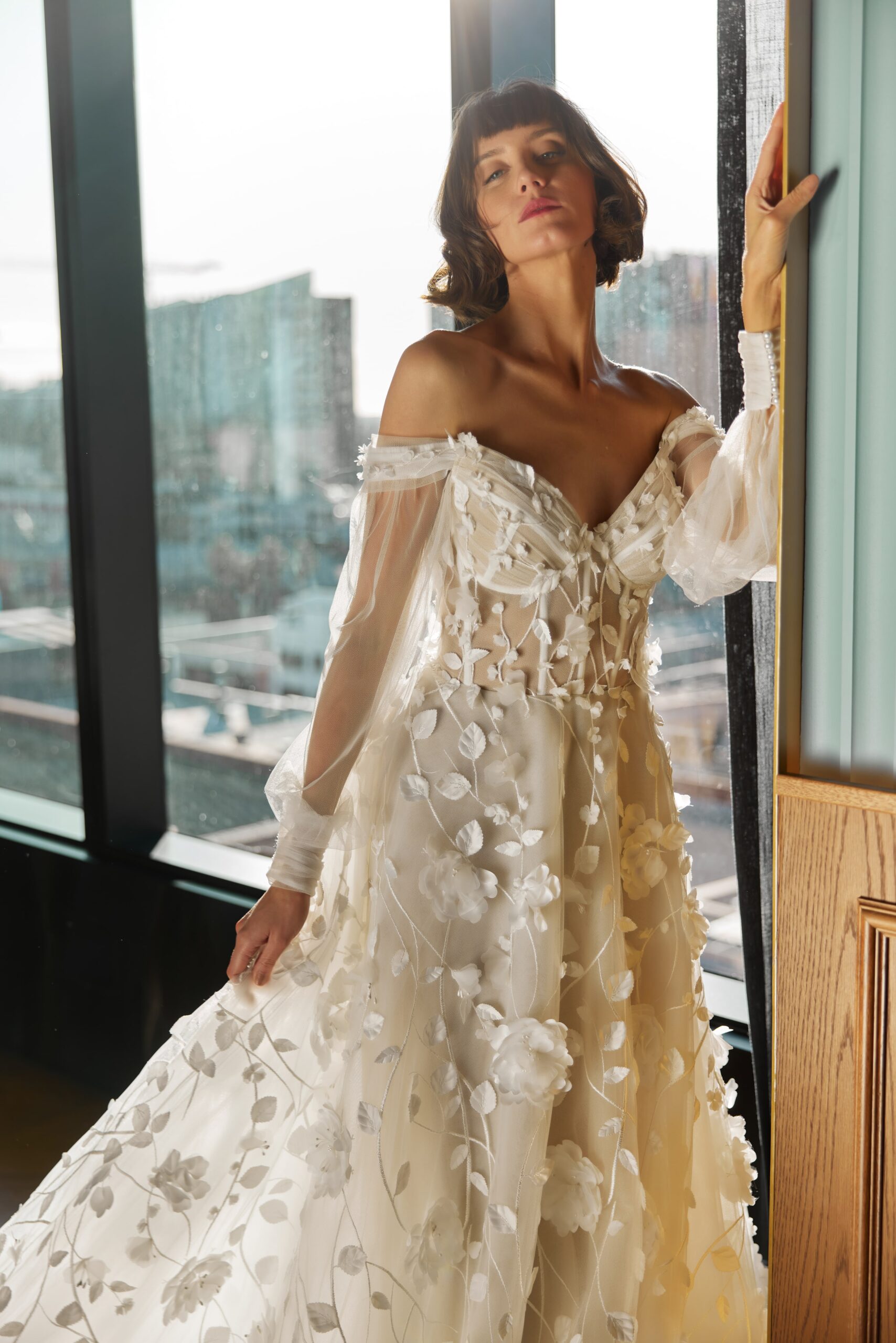 Florentine - a 3D floral lace gown with a sheer corset bodice, soft tulle off-the-shoulder sleeves and full skirt.