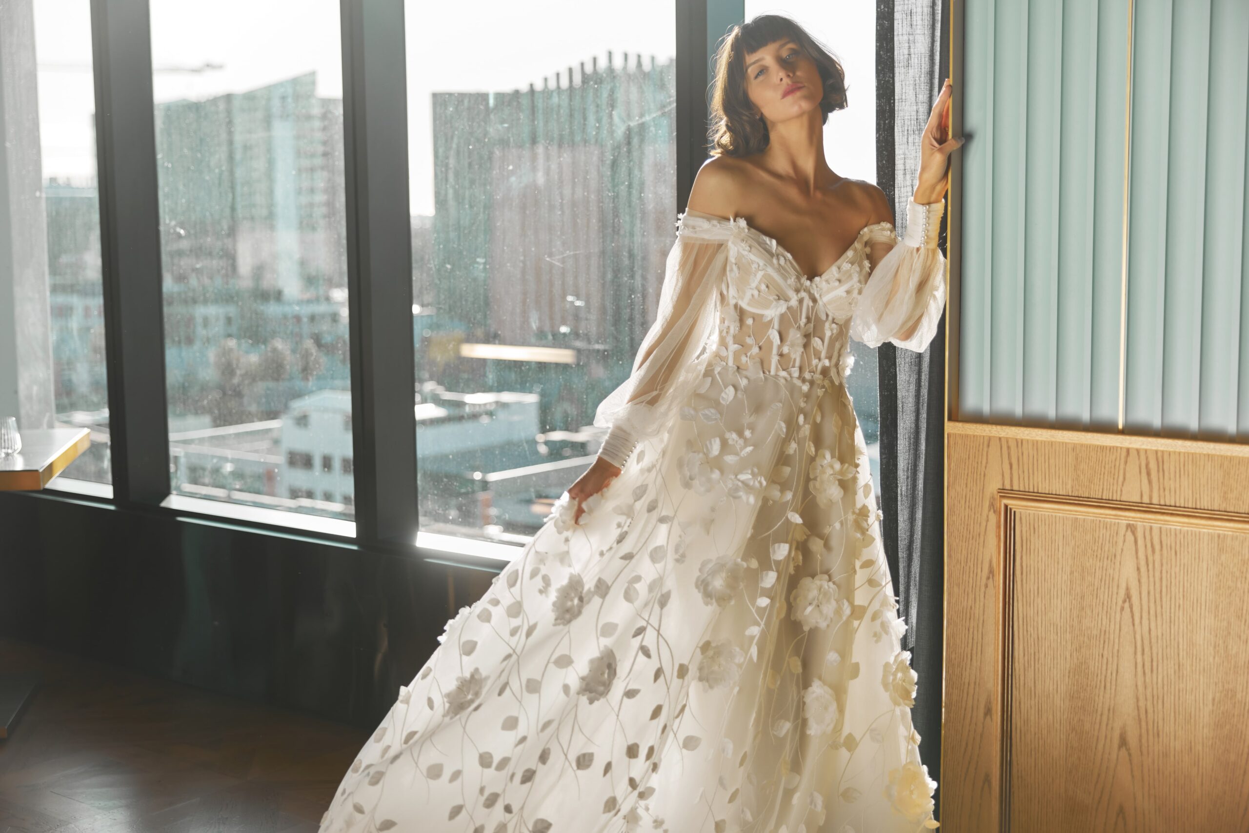 Florentine - a 3D floral lace gown with a sheer corset bodice, soft tulle off-the-shoulder sleeves and full skirt.