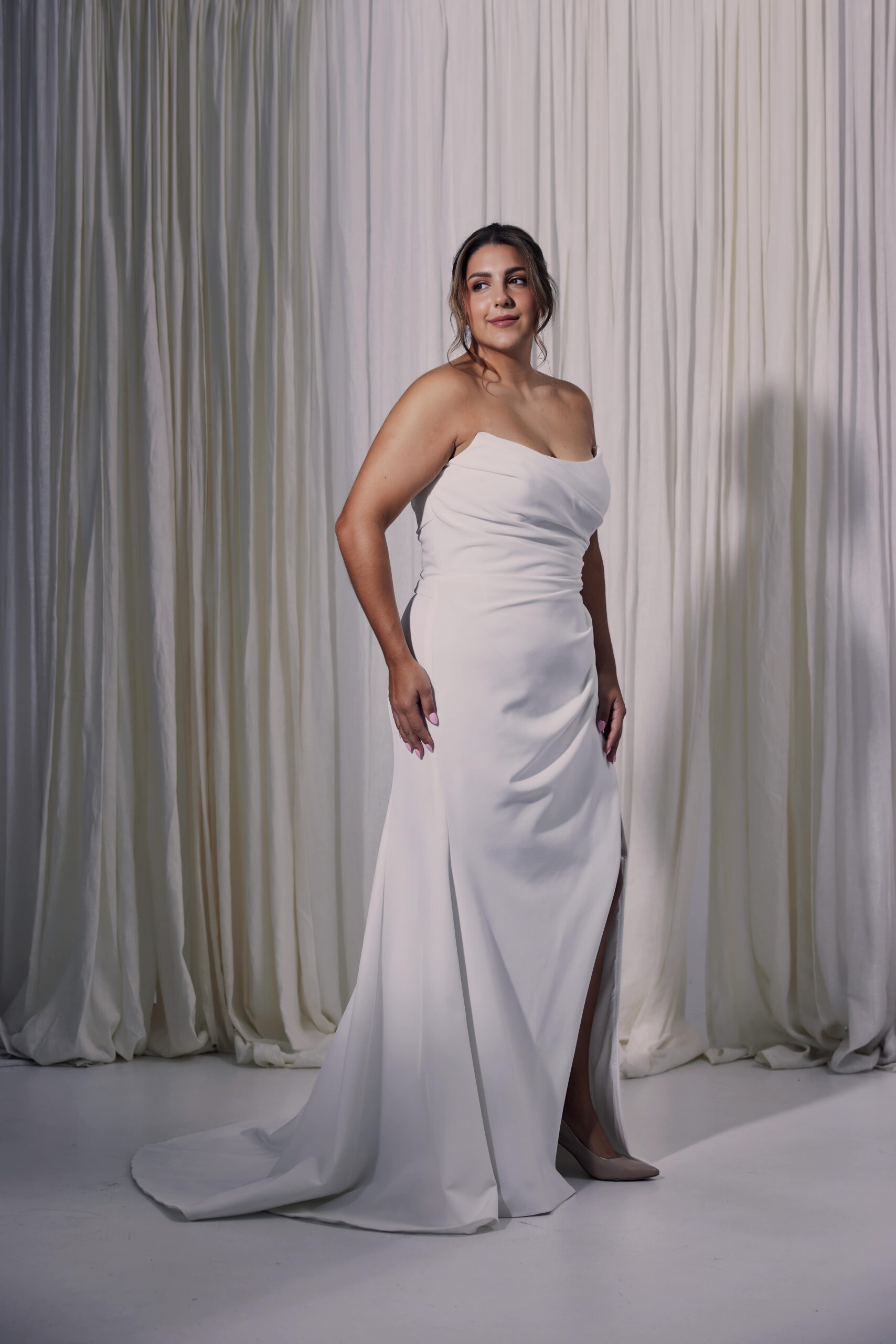 The Carol gown - a fitted gown with draping, scoop neckline and a side split.