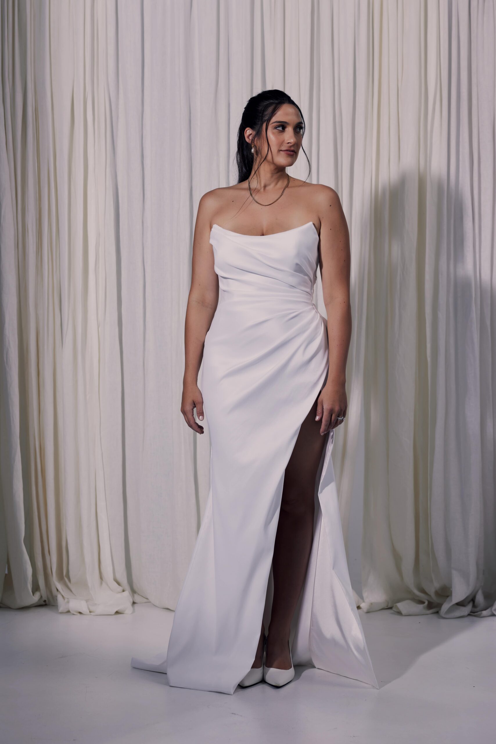 The Carolina gown - a stretch twill gown with draping, scoop neckline and a side split.