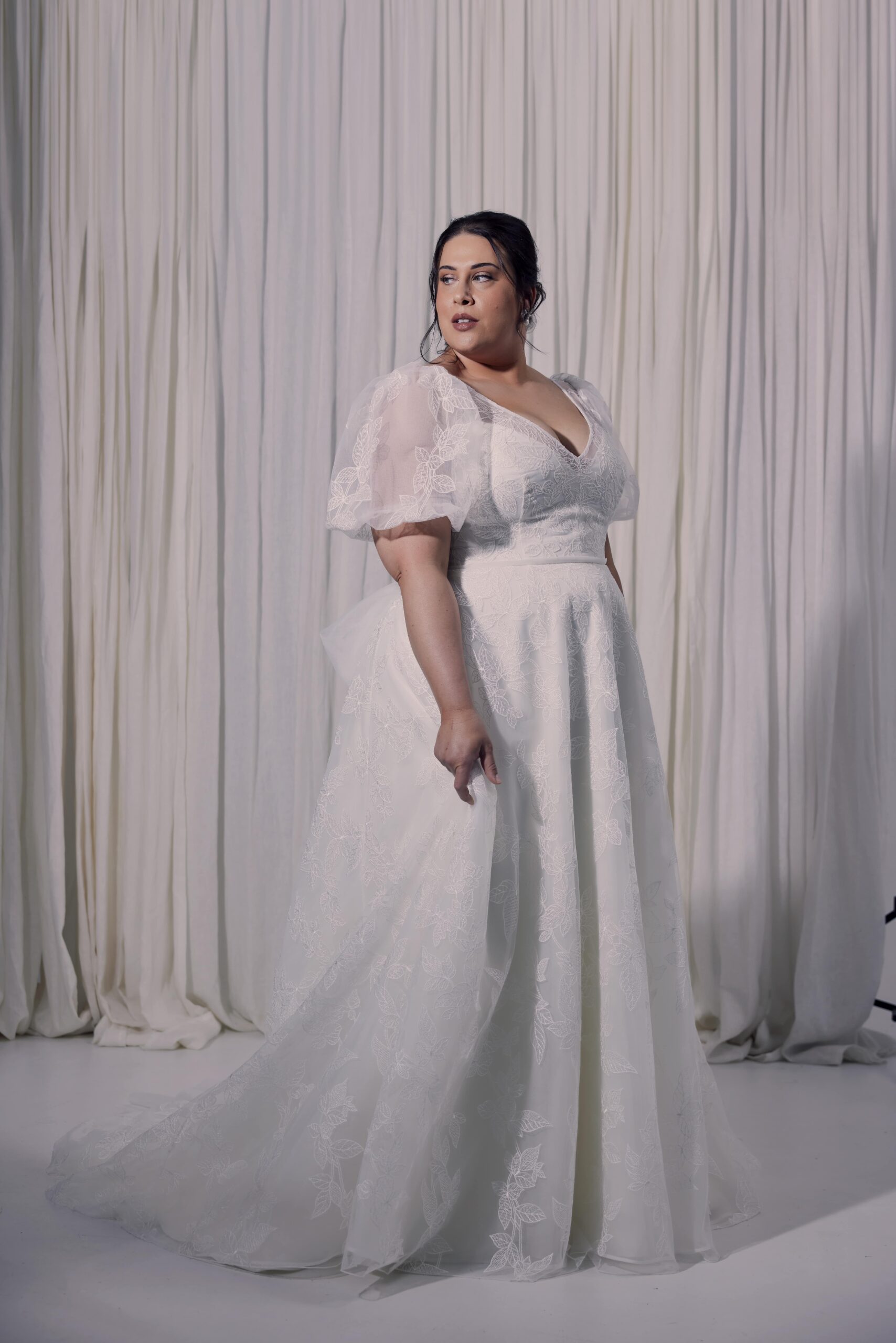 The Floretta gown - an A-line embroidered tulle gown with all-over leaf design. Floretta features a v-neckline with sheer puff sleeves and a satin underbodice.