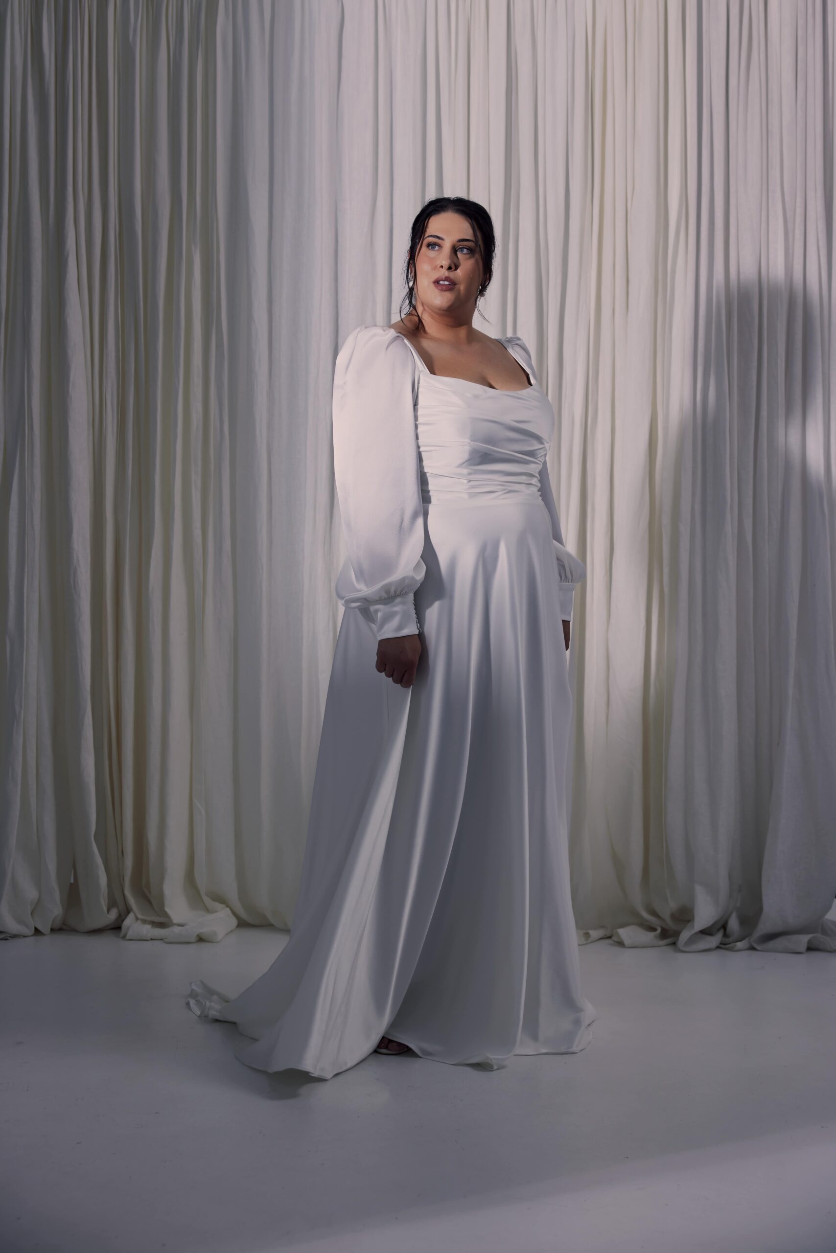 The Luna gown - a satin gown with soft bodice draping, soft bishop sleeves and a soft flowing a-line skirt.