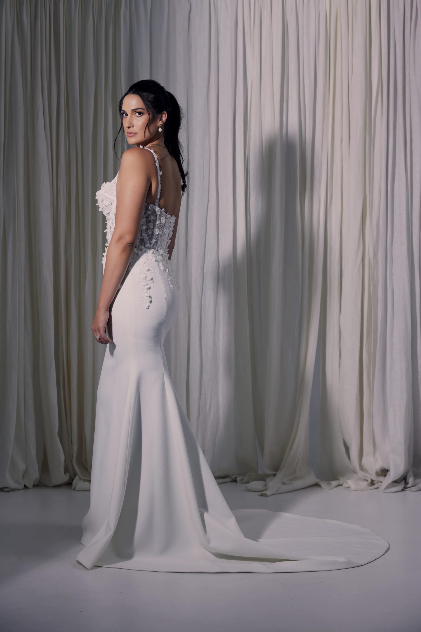 The Celena gown - a fit and flare silhouette with a sculpted sheer bodice with exposed boning and 3D lace.
