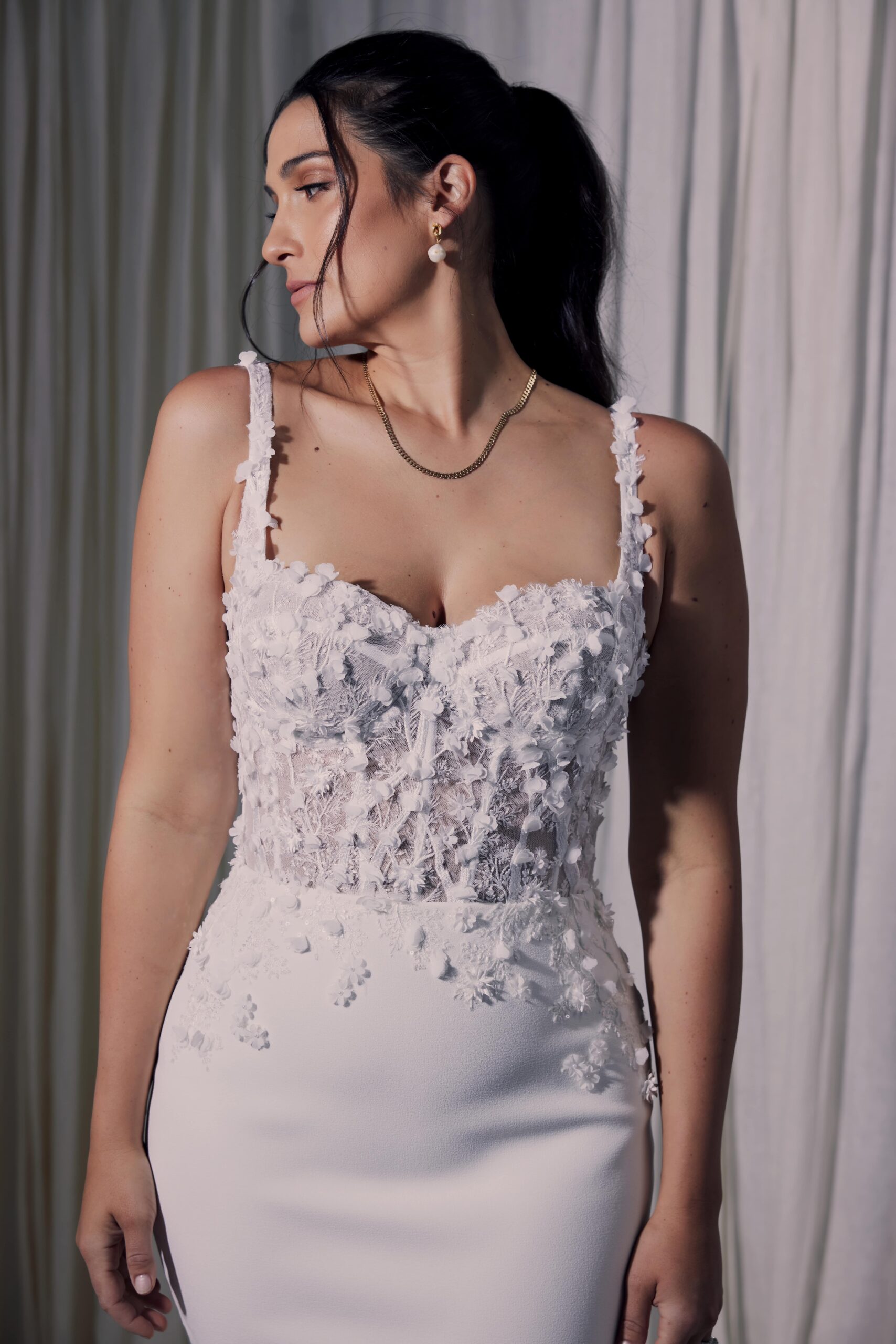 The Celena gown - a fit and flare silhouette with a sculpted sheer bodice with exposed boning and 3D lace.