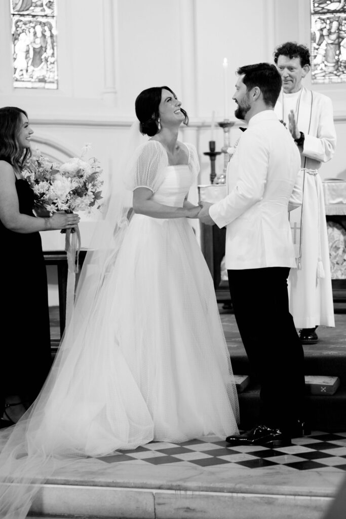 Maddy and Jason at the alter, holding hands and laughing