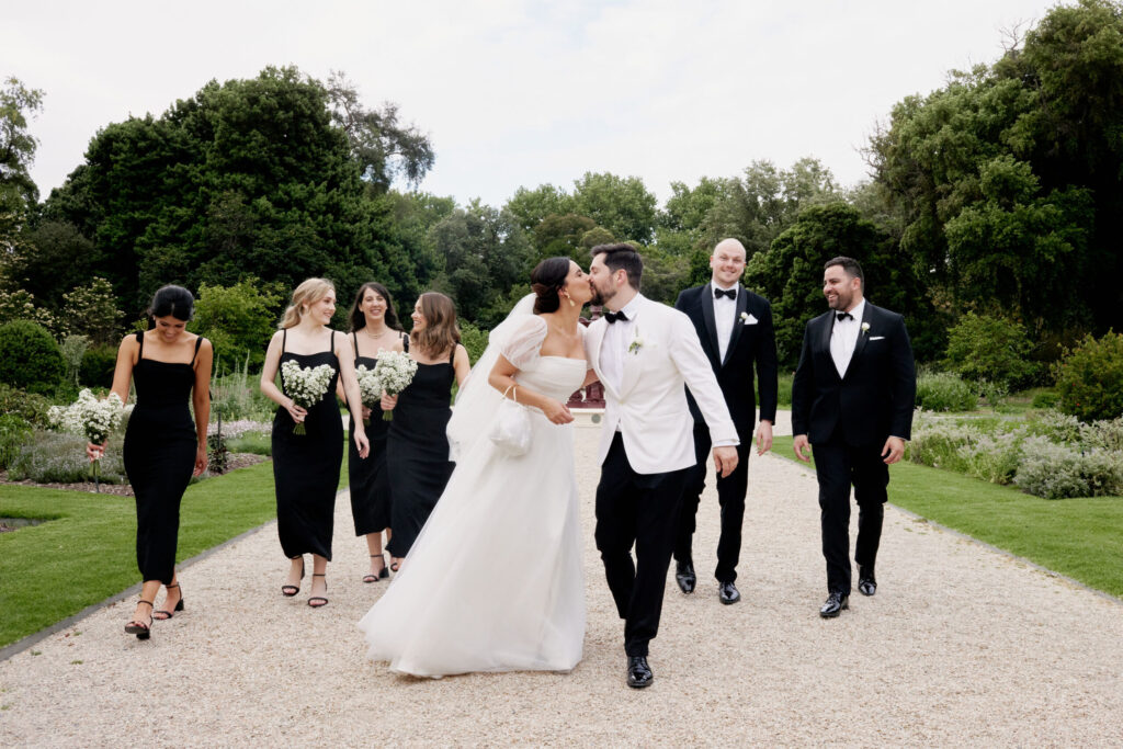 Maddy and Jason with bridal party walking through the botanical gardens