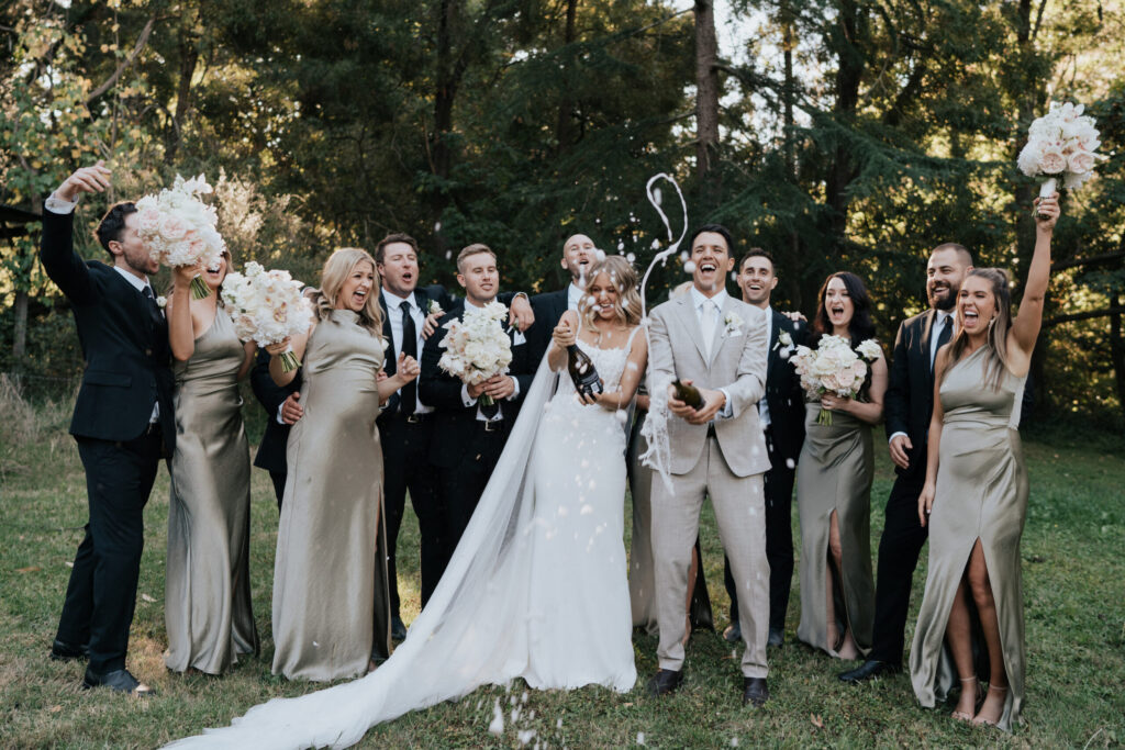 Bridal party popping champagne