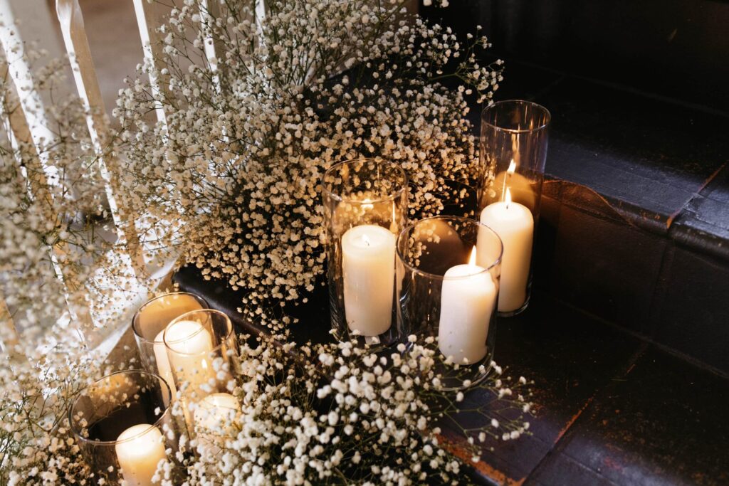 Candles and baby's breath plant scattered along the sides of the staircase."