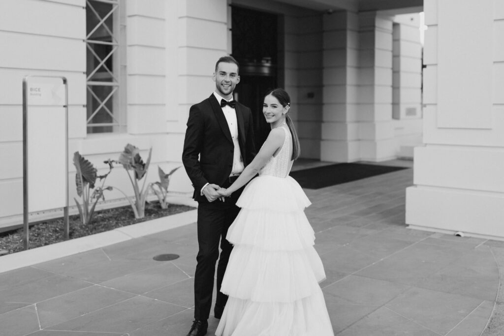 Bethany and Daniel couple portrait - infront of the white brick city building