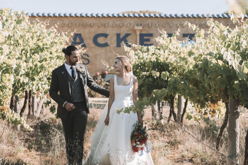 Maia and Andrew walking through vineyards