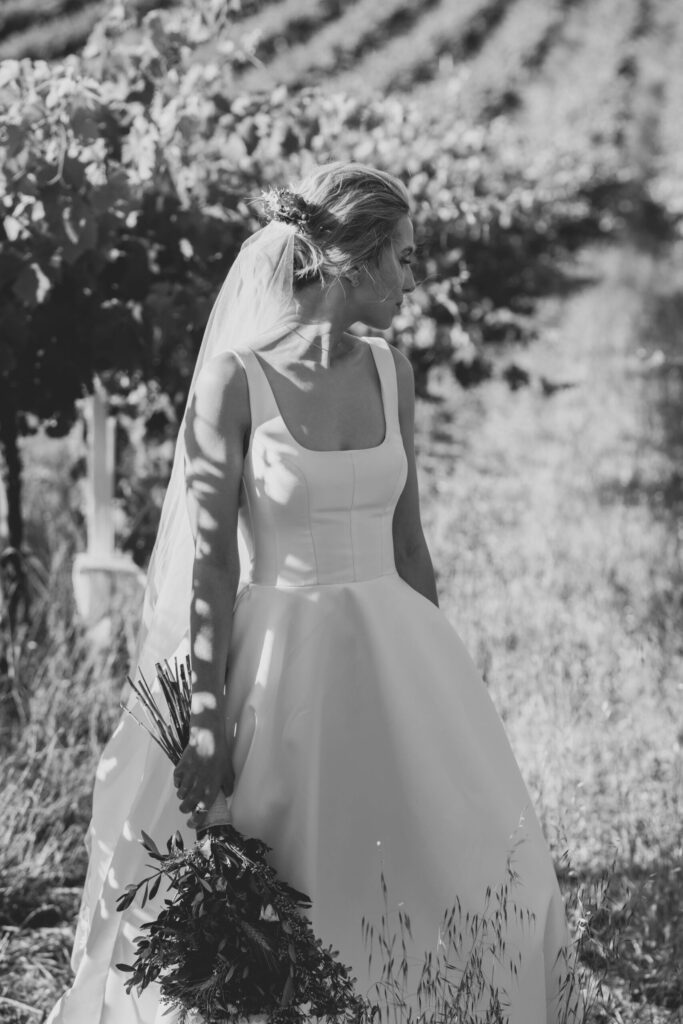 Black and white portrait shot of Maia in her gown from the front. The gown has a square neckline and full skirt.