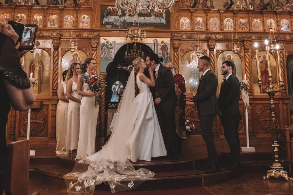 Maia and Andrew at the church altar - sharing a kiss