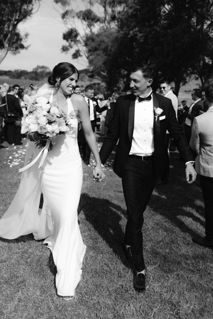 Olivia and Patrick holding hands walking down the aisle leaving the ceremony