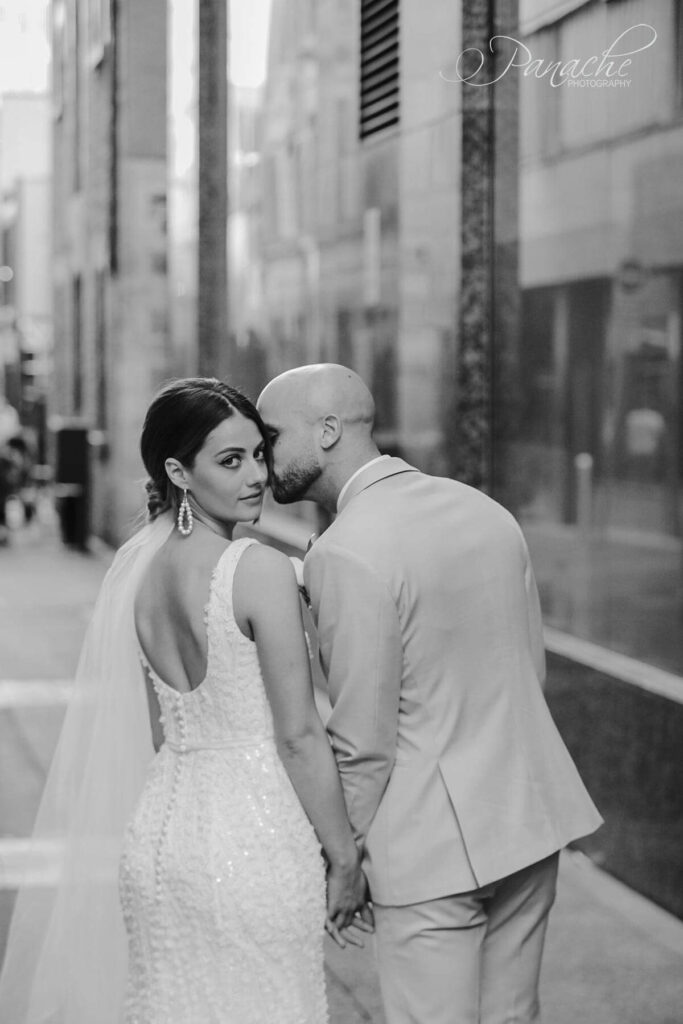 Jake giving Cristiana a kiss on the cheek as they stand on a city street